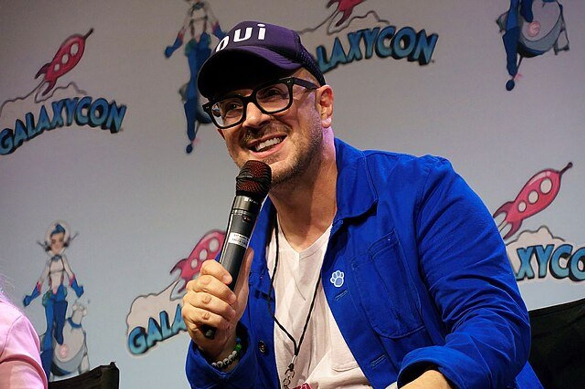 Steve Burns smiling and holding a microphone