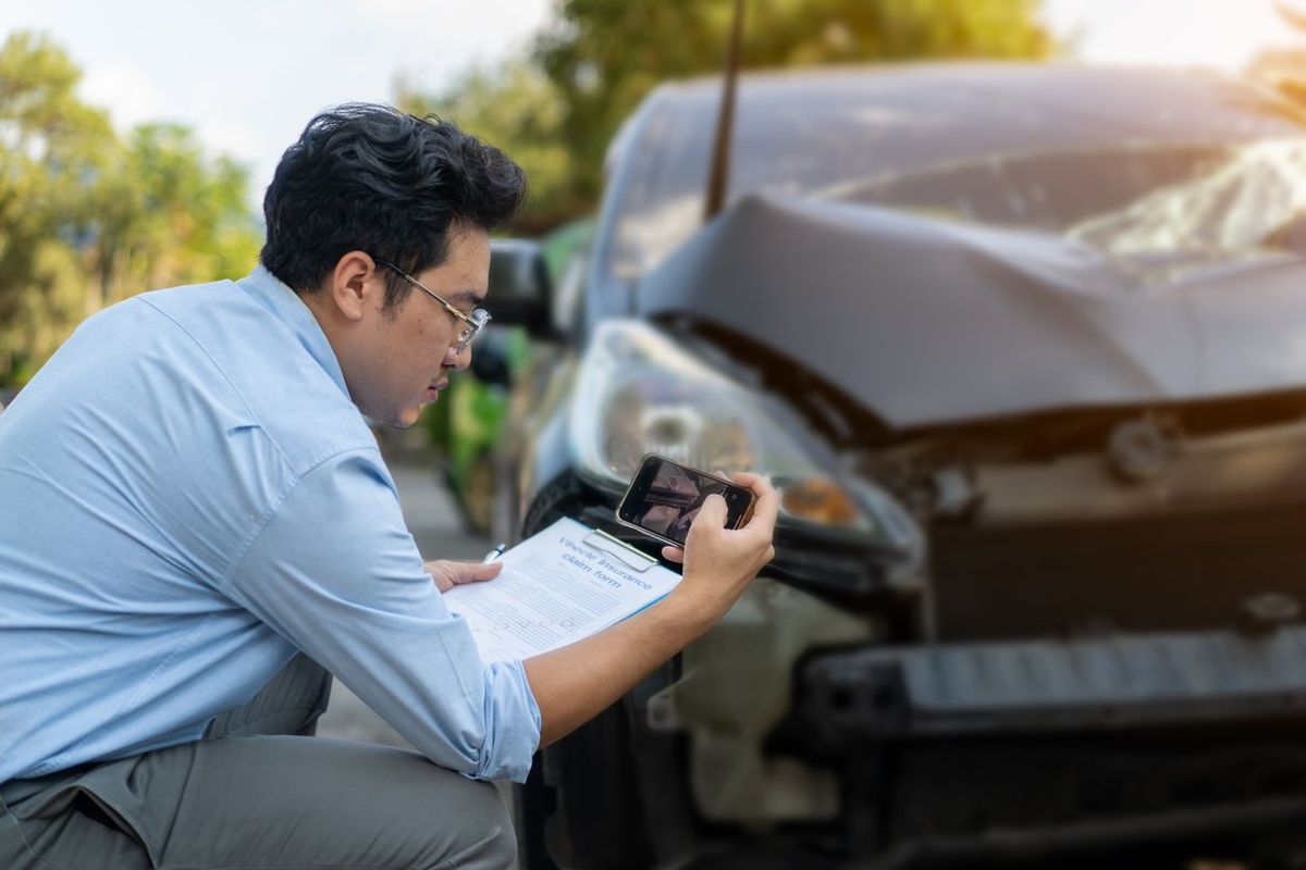 a photo of a person taking pictures of a car wreck