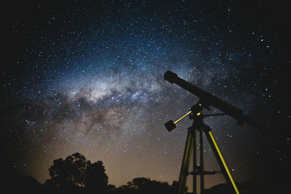 photograph of a telescope pointing at the night sky