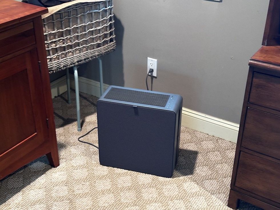 a photo of Airthings Renew Air Purifier in a room plugged in and cleaning the air.