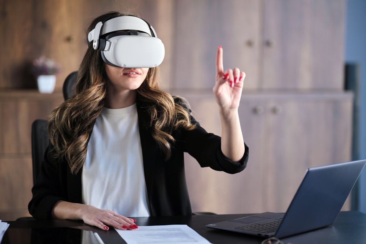 a woman wearing a vr headset while working on a computer