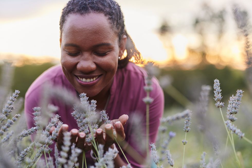 Black-woman-with-a-smile-smelling-a-field-of-lavender