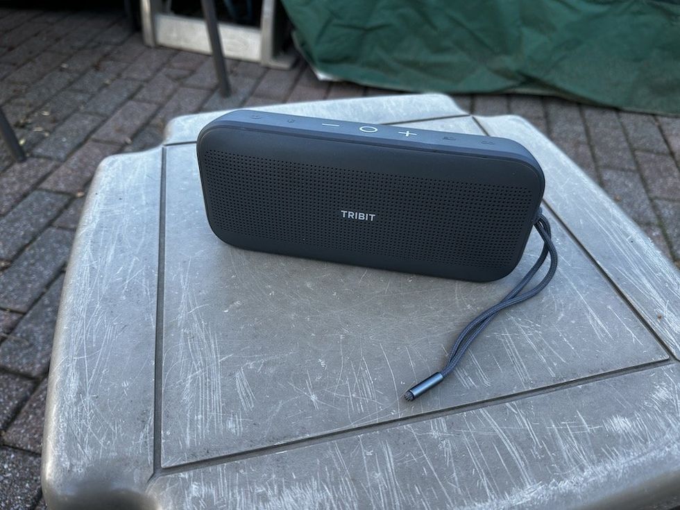 a photo of Tribit StormBox Flow Portable Wireless Speaker outside on a table.