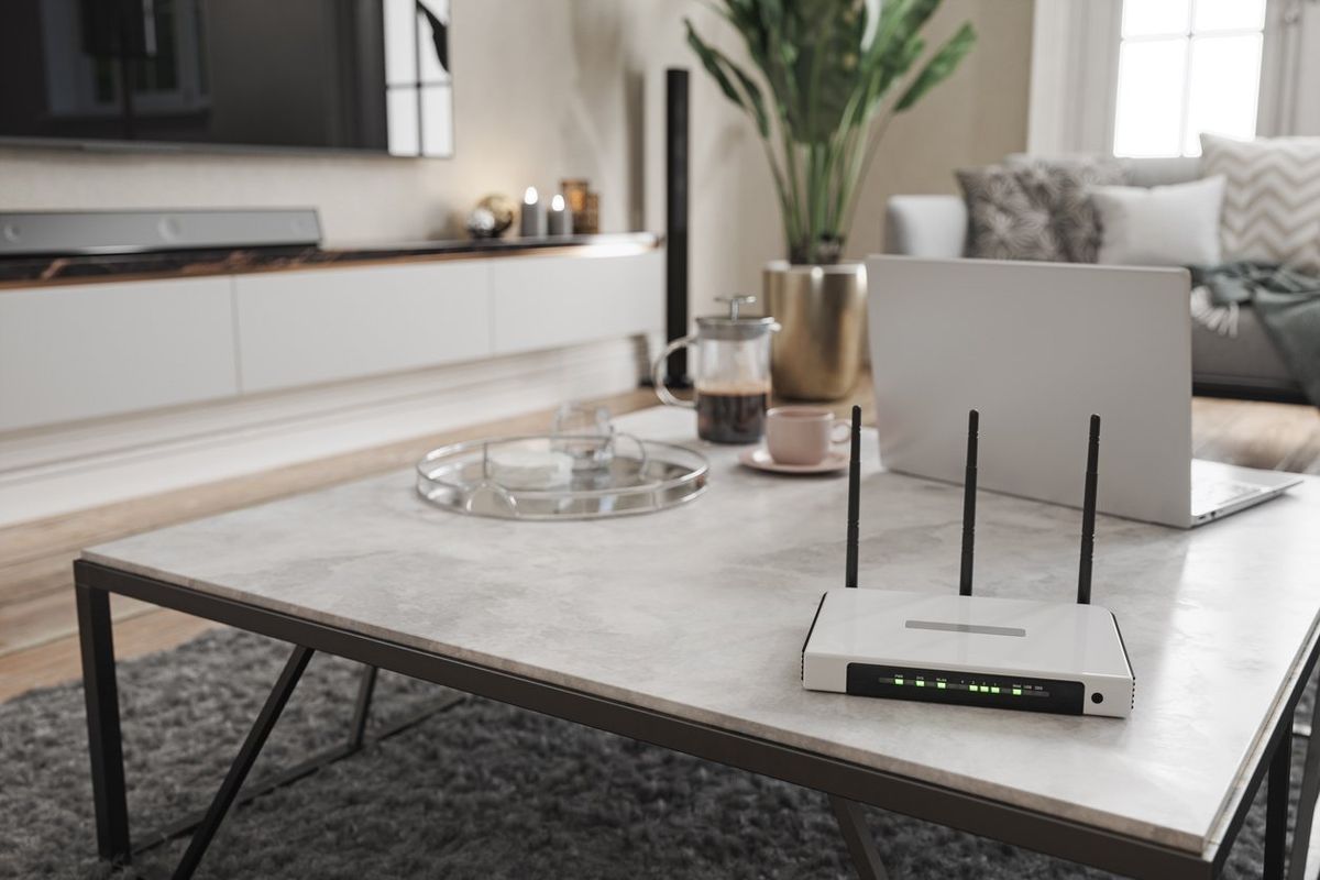 a photo of a living room with a router, laptop on a coffee table.