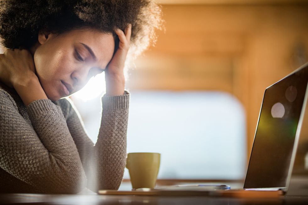 Fatigued-black-woman-taking-a-break-at-work-in-front-of-her-laptop