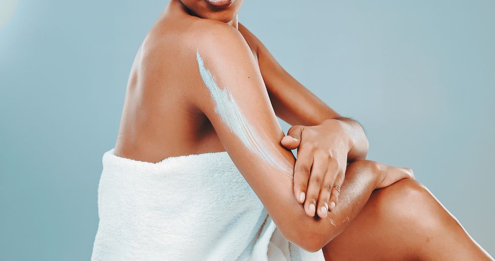 Faceless-woman-moisturizing-her-skin-in-a-bath-towel