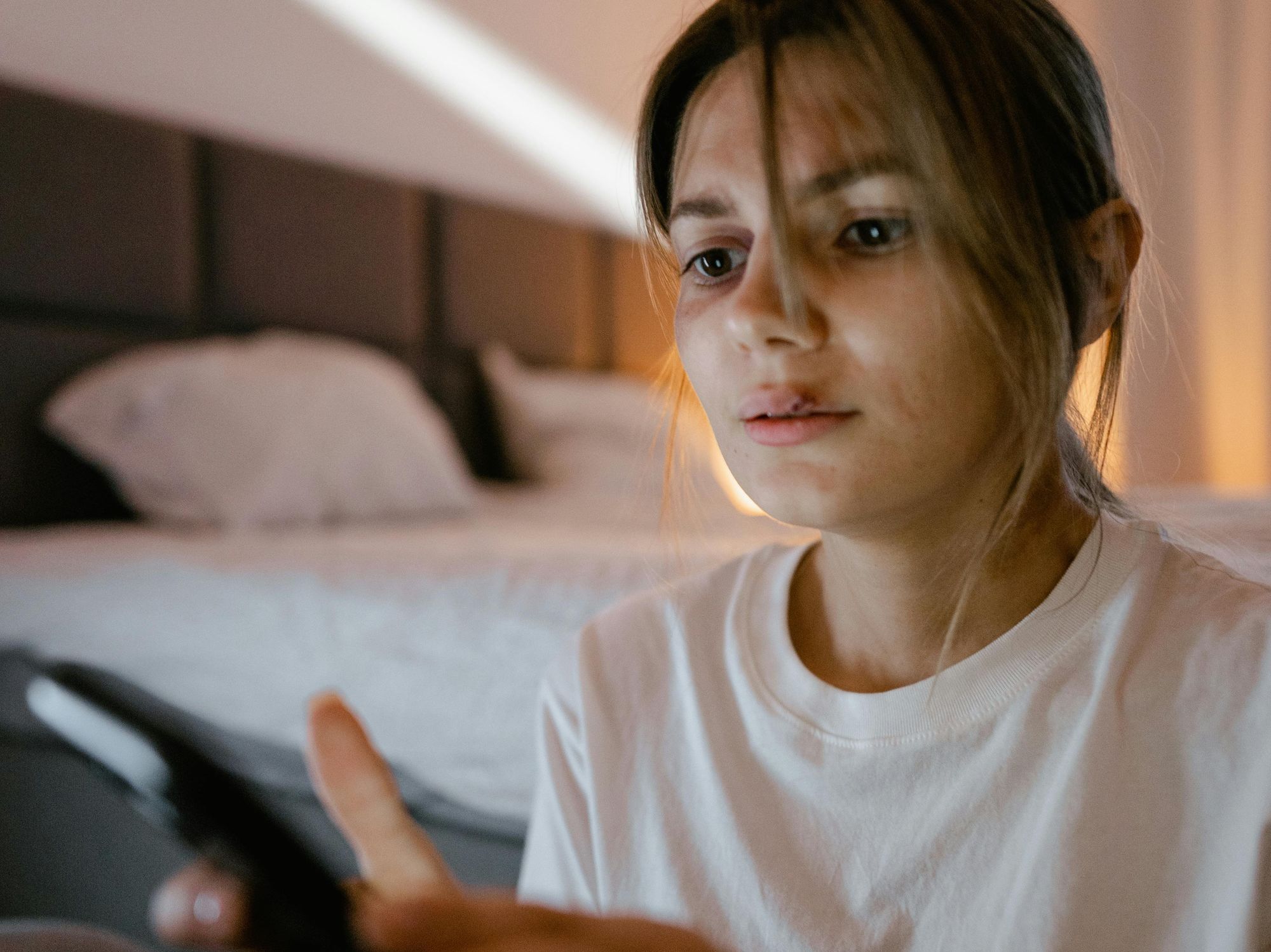 young woman looking at her phone screen with sad expression