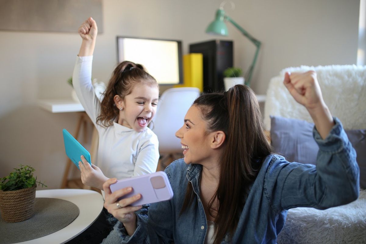 mom and child celebrating Mother's Day while both are on their smartphones.