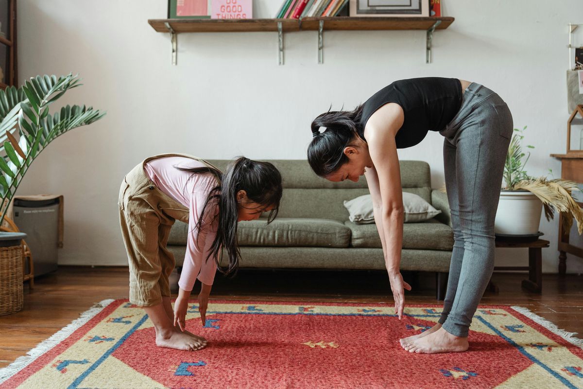 mother and daughter reaching down to touch their toes
