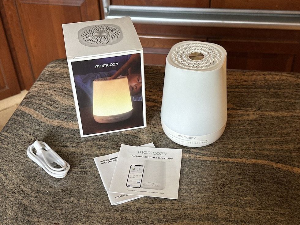 a photo of Momcozy Smart Baby Sound Machine unboxed on a countertop
