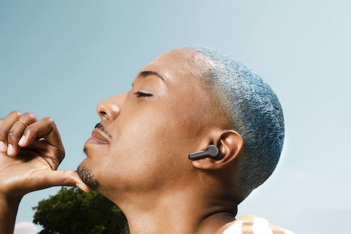 a photo of a man wearing Echo Buds (2023 release) outside.