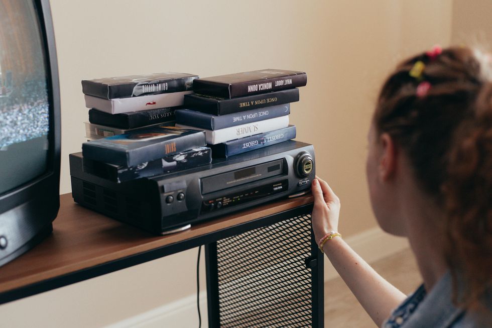 vcr with vhs tapes piled on top of it