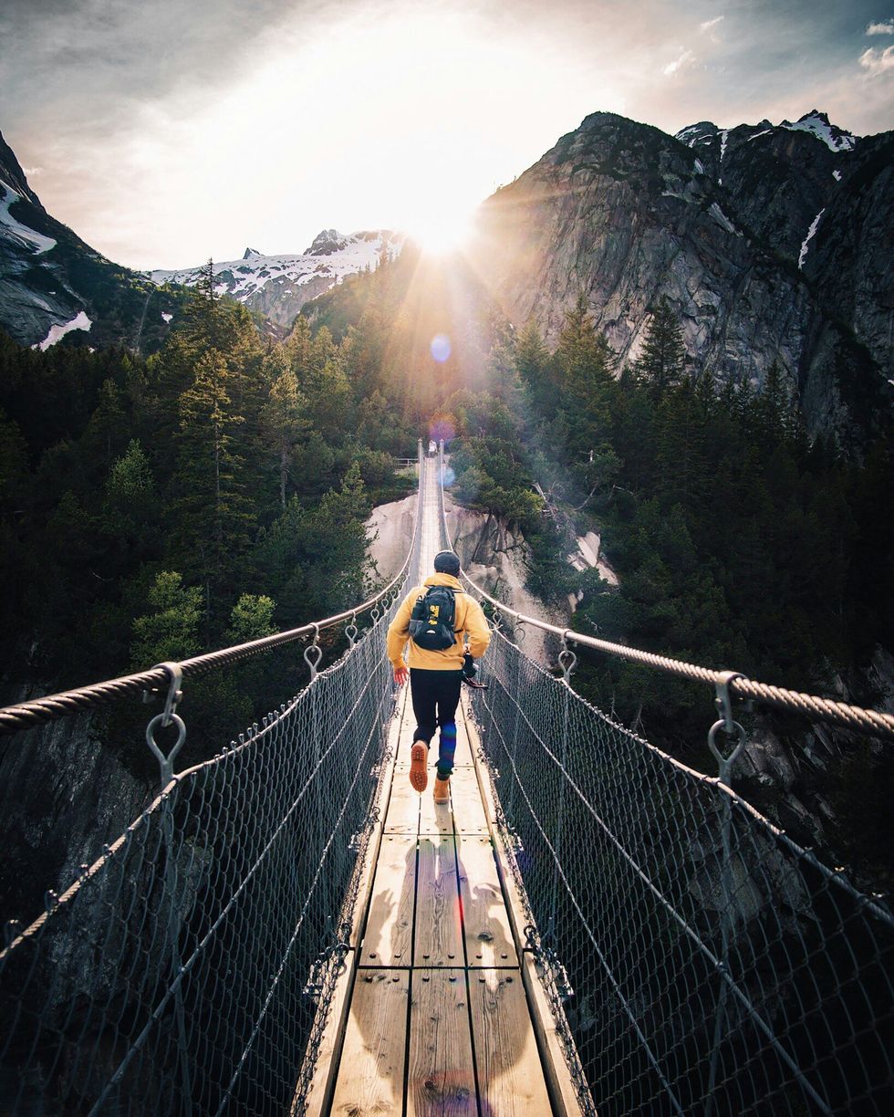 person walking across a wooden bridge