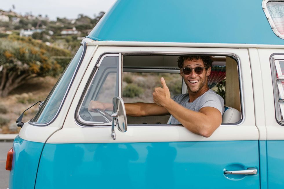 Man in a van smiling and giving a thumbs up sign