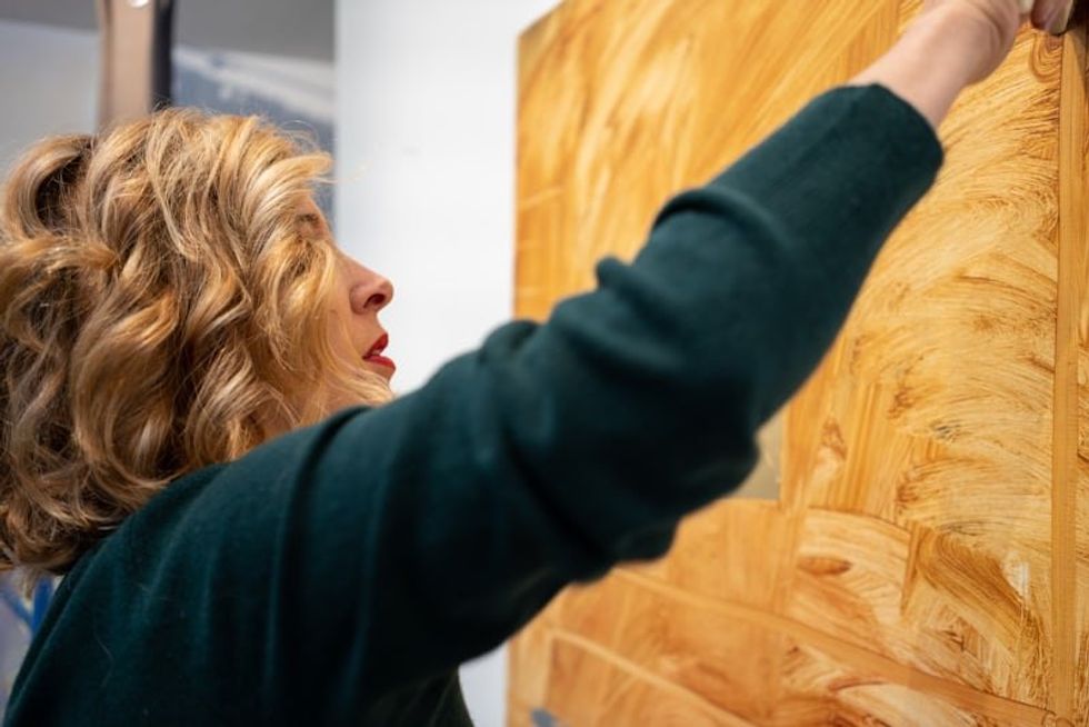 woman hanging a piece of art