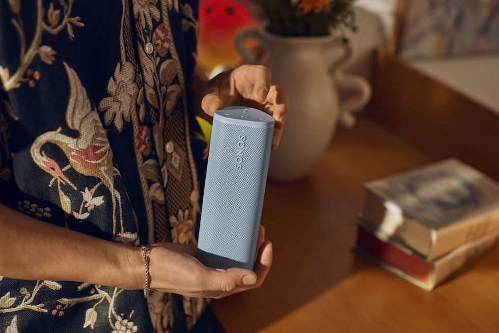 a person holding a Sonos Roam 2 Portable Wireless Speaker