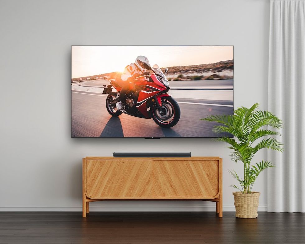 a photo of the TCL S Class Sound Bar installed on a table with large screen TV attached.