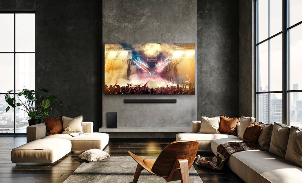 a photo of a living room with a smart TV on the wall with TCL soundbar underneath