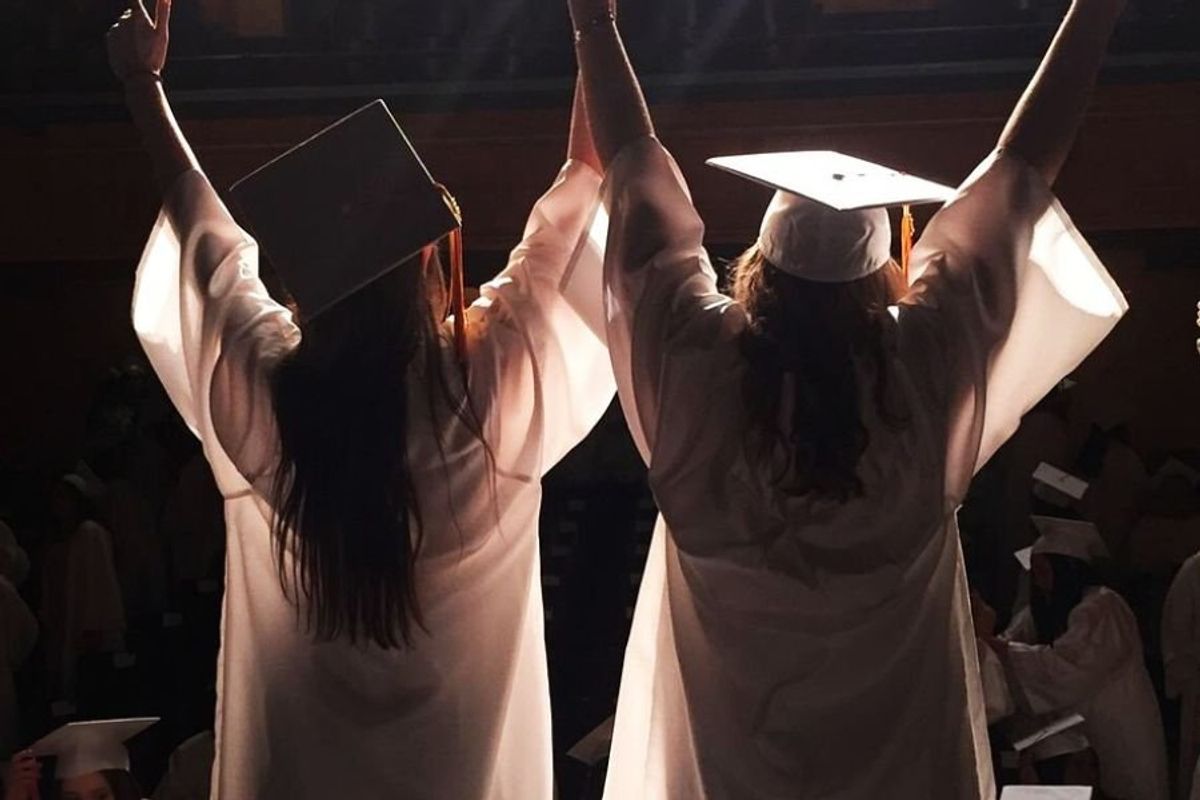 two graduates in cap and gown