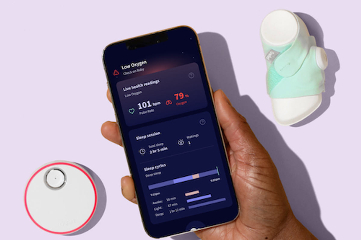 a photo of a smartphone showiing the Owlet app with the Owlet Dream sock and hub