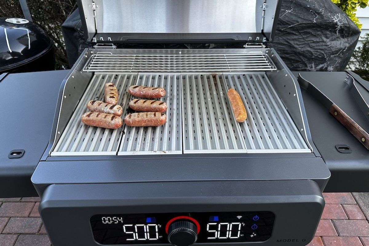 a photo of cooking sausage on Current Model G Dual Zone electric grill