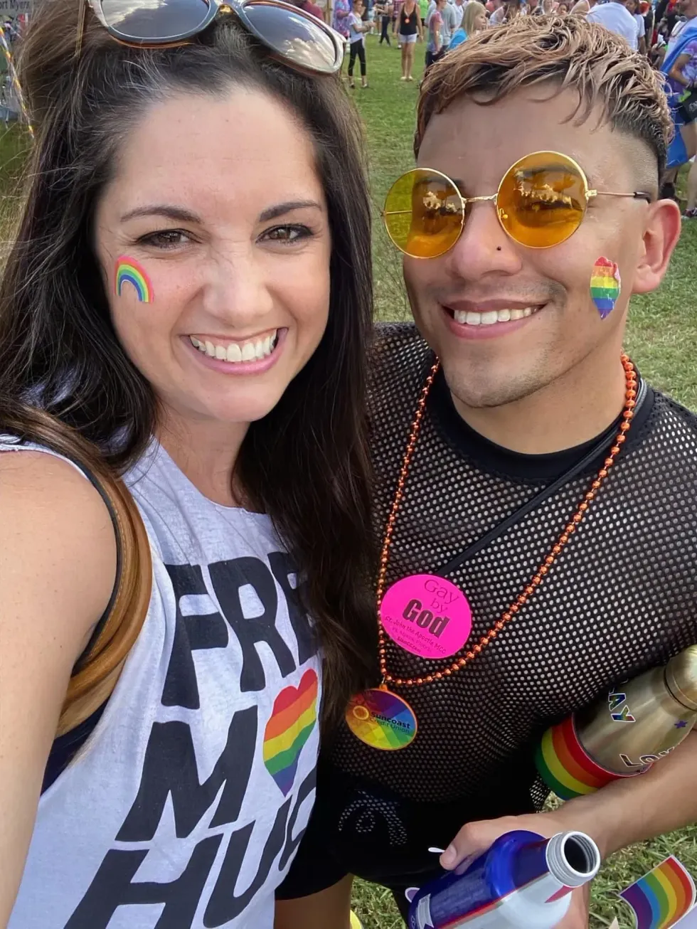 Two people smiling together wearing Pride gear