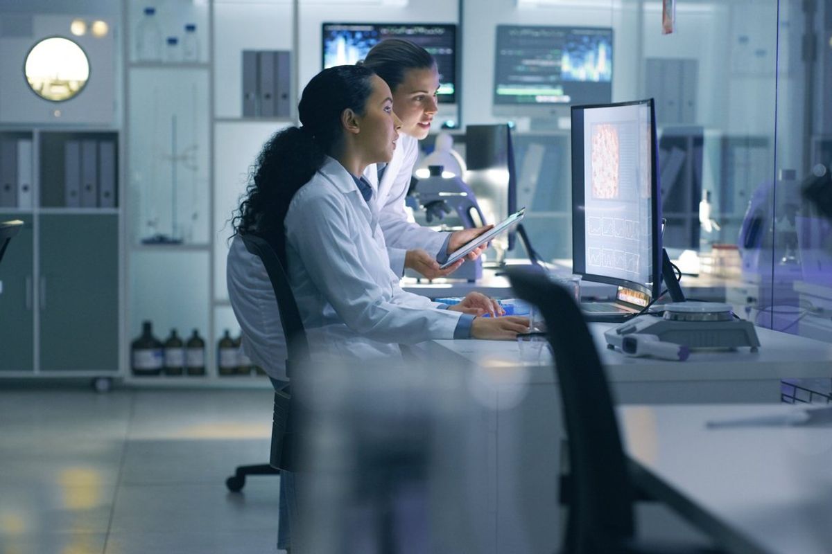 a photo of scientist in a lab working on computers and medical devices to help solve healthcare issues.