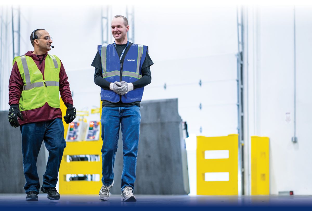 Photo of two warehouse associates walking. 