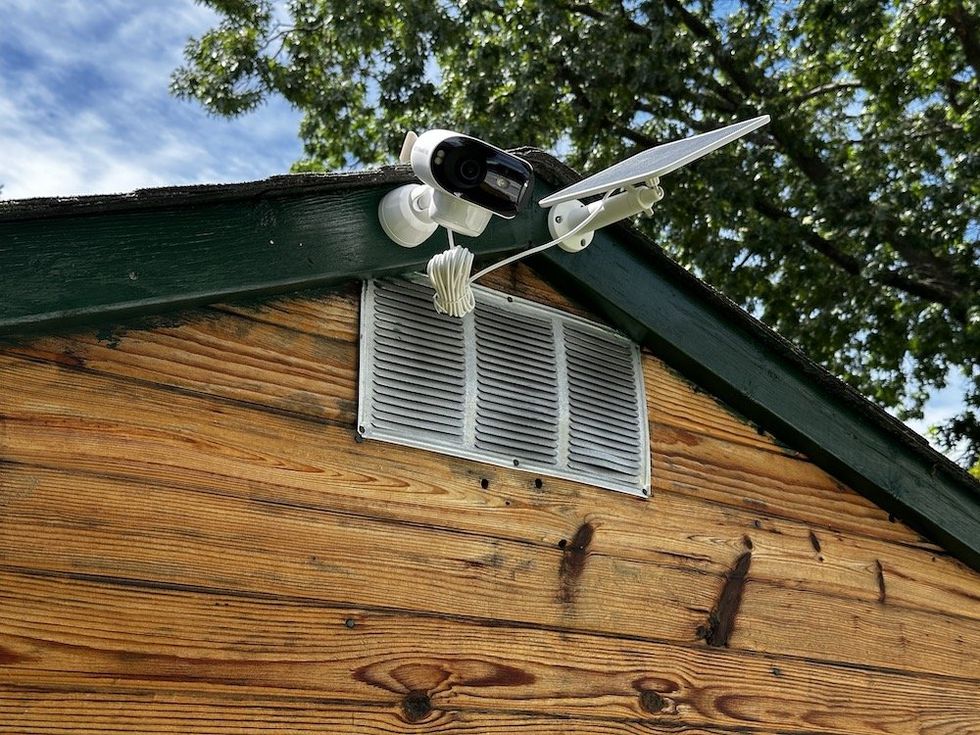 a ground view of Argus 4 Pro and solar panel installed outside on a shed