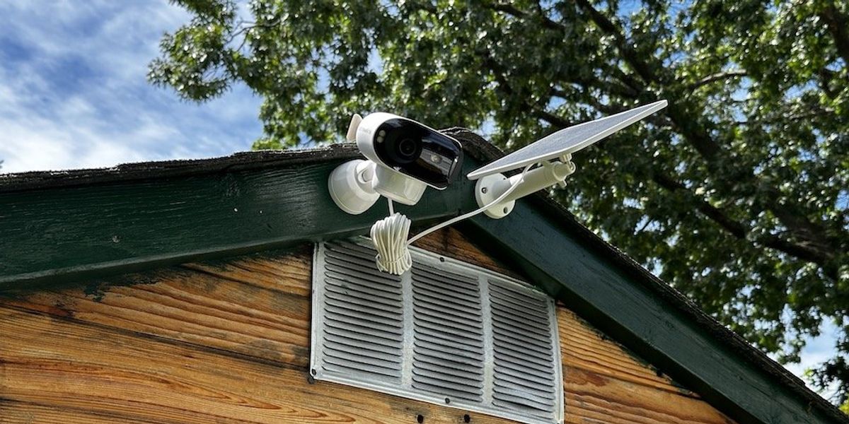a ground view of Argus 4 Pro and solar panel installed outside on a shed