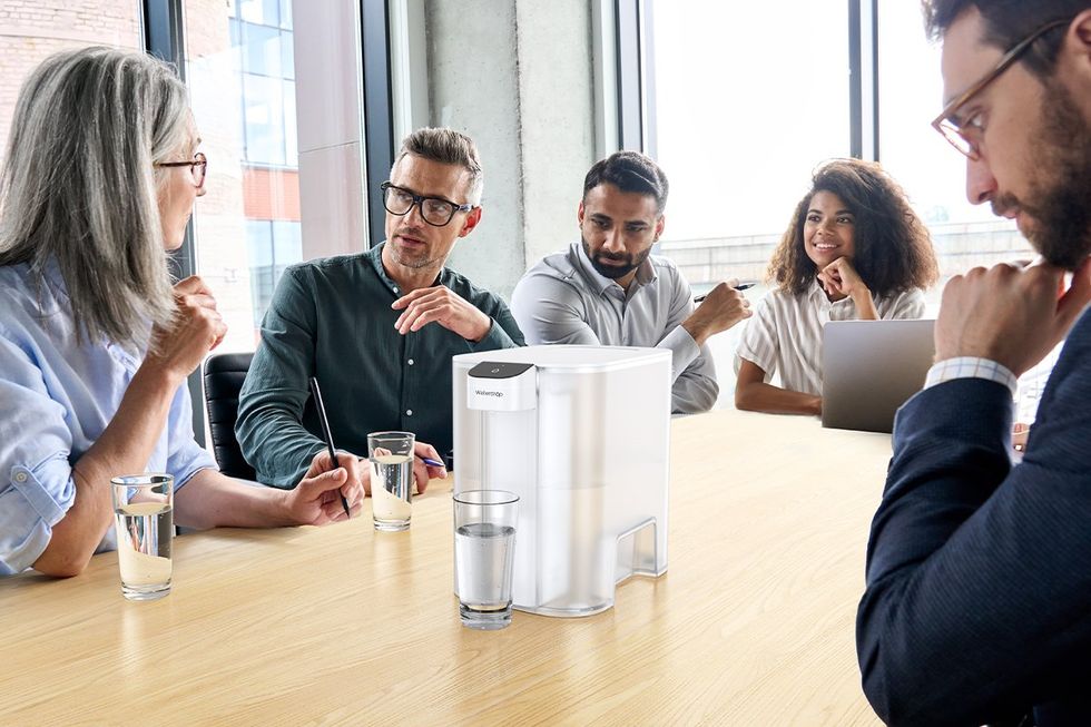 a photo of a business meeting with Waterdrop Filter and glasses of water on the conference table.
