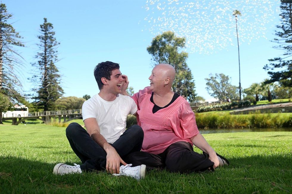 woman bald from chemo laughing with her adult son