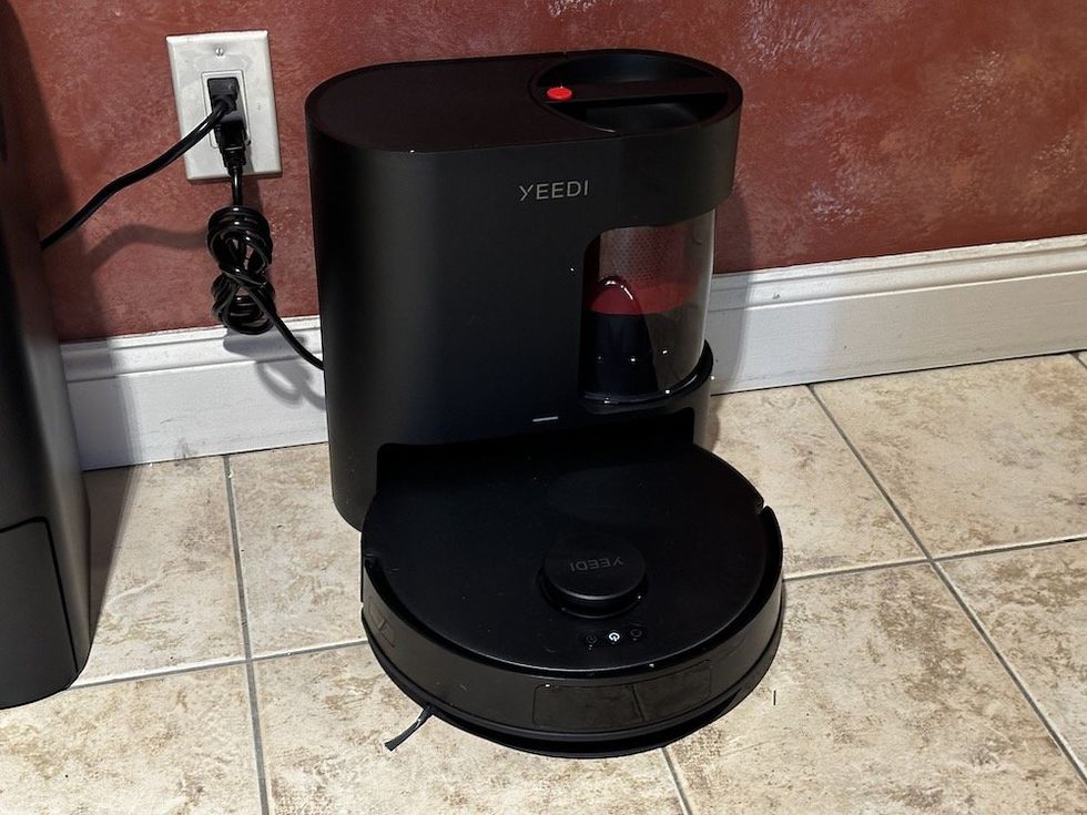 a photo of the Yeedi C12 Pro Plus Robot vacuum and selt-emptying station in a kitchen.