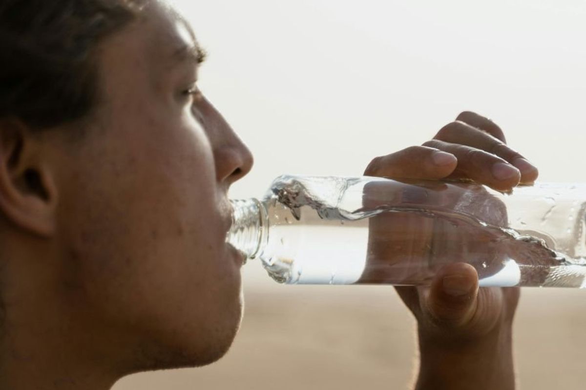 person drinking water from a bottle