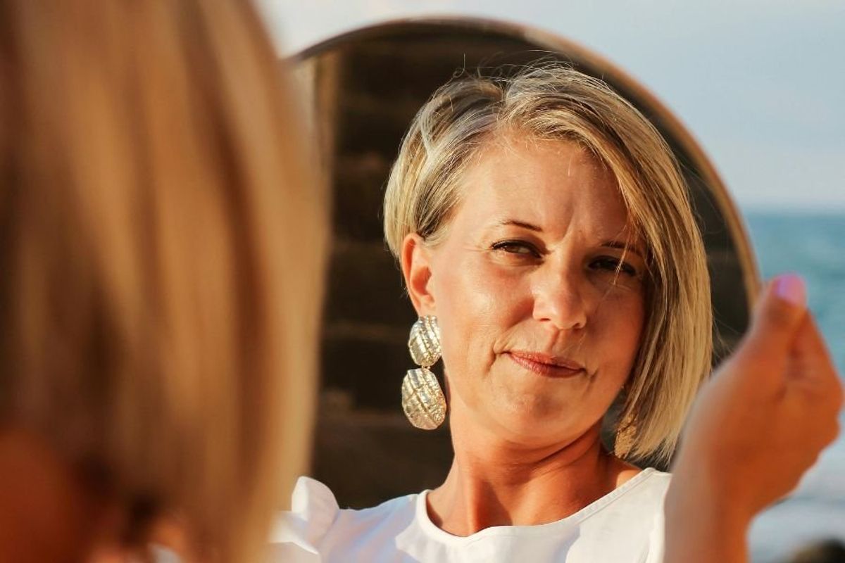 middle-aged woman looking in the mirror