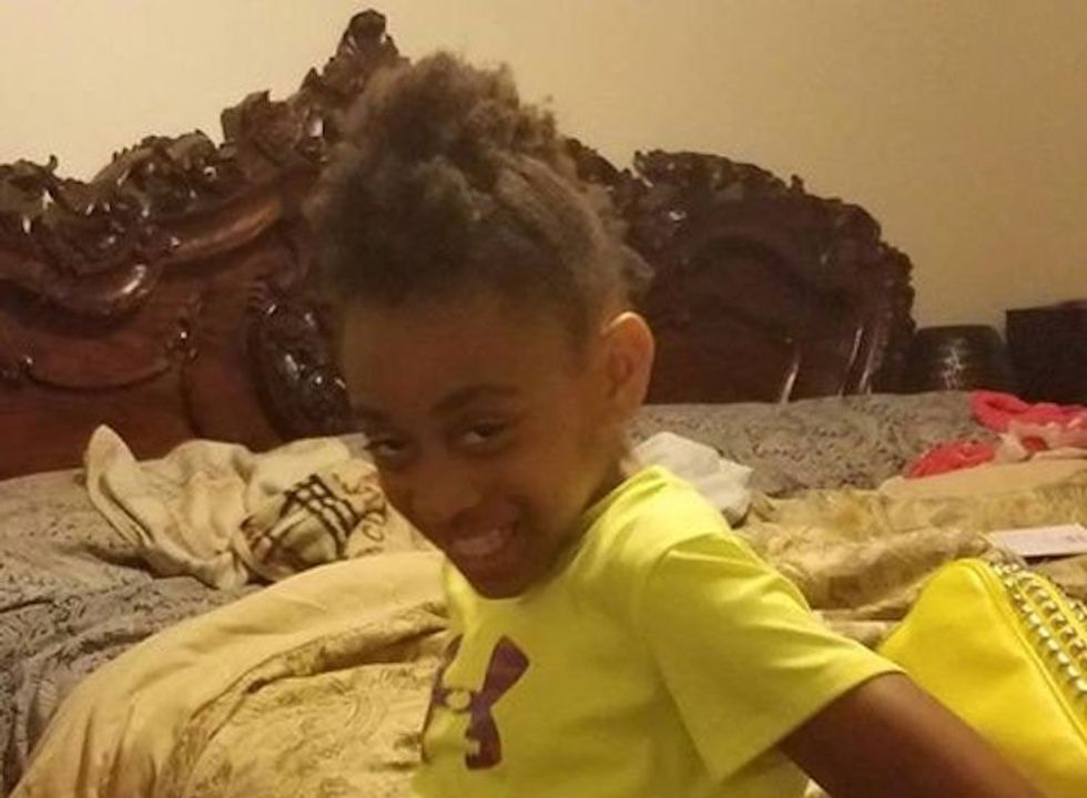 A girl in yellow shirt smiling at the camera