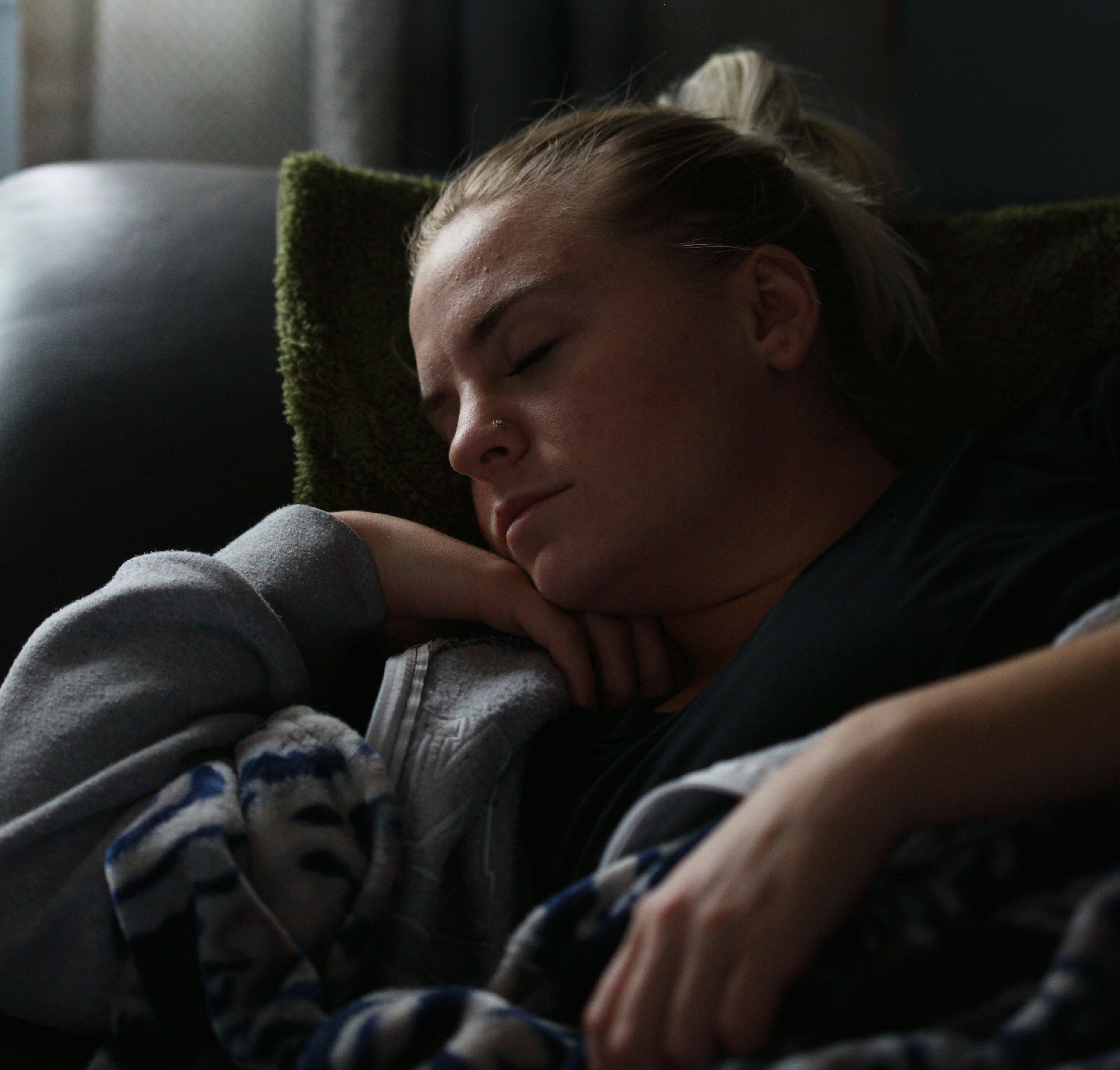 woman in black shirt lying on couch