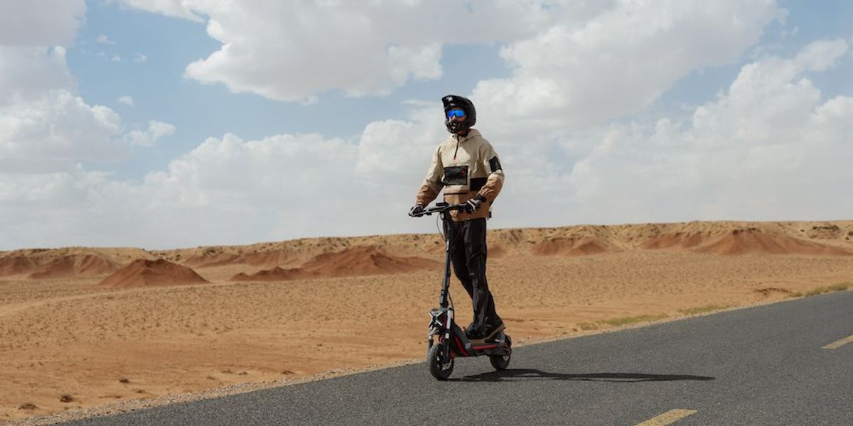 a photo of a man riding a Segway ZT3 Pro All-Terrain eKickScooter on the road