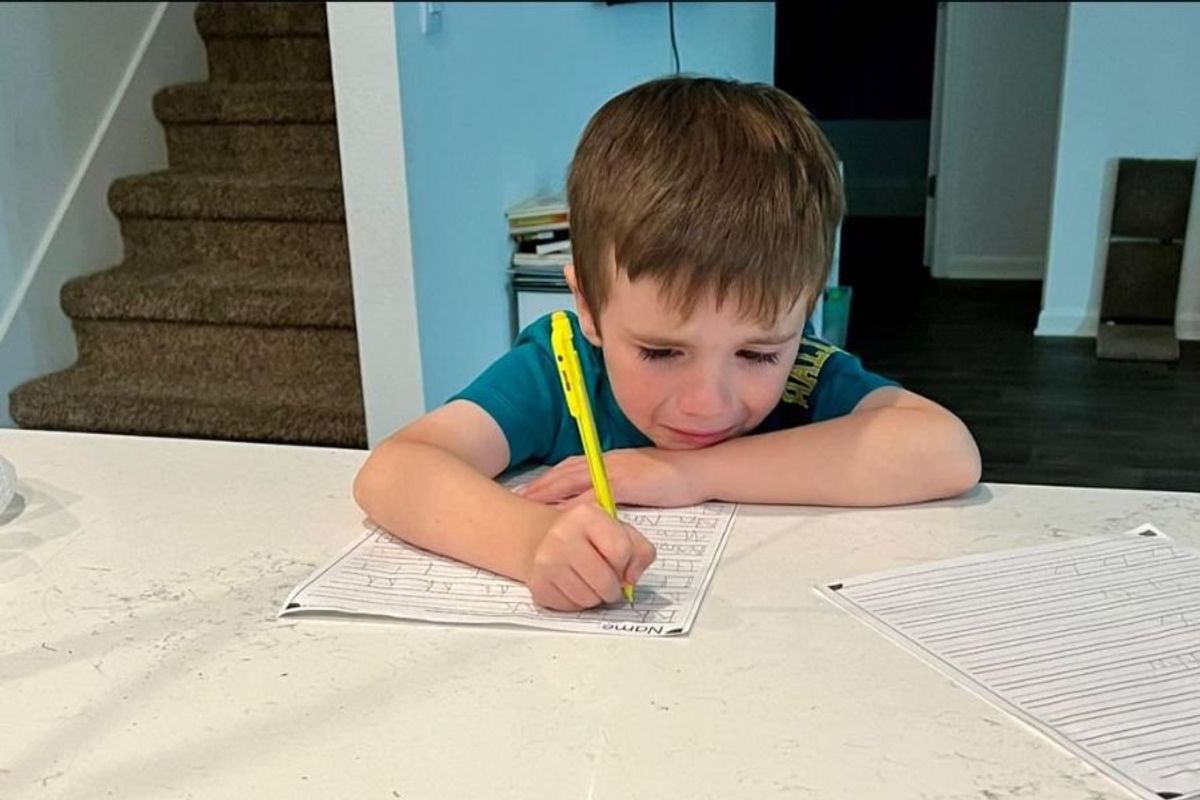 little boy in tears as he's doing homework