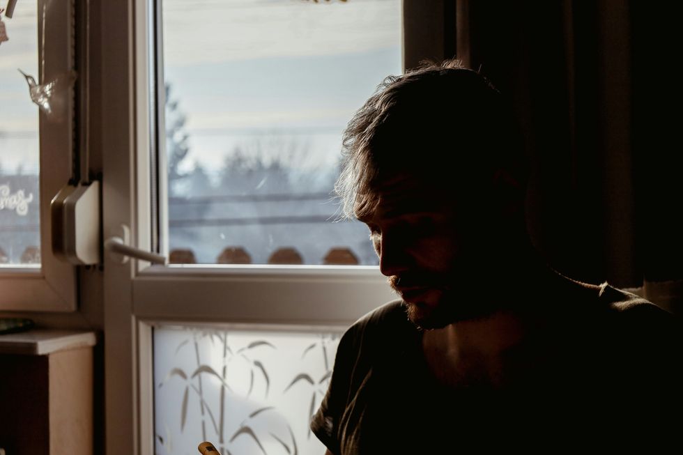 a man looking at his cell phone in the dark