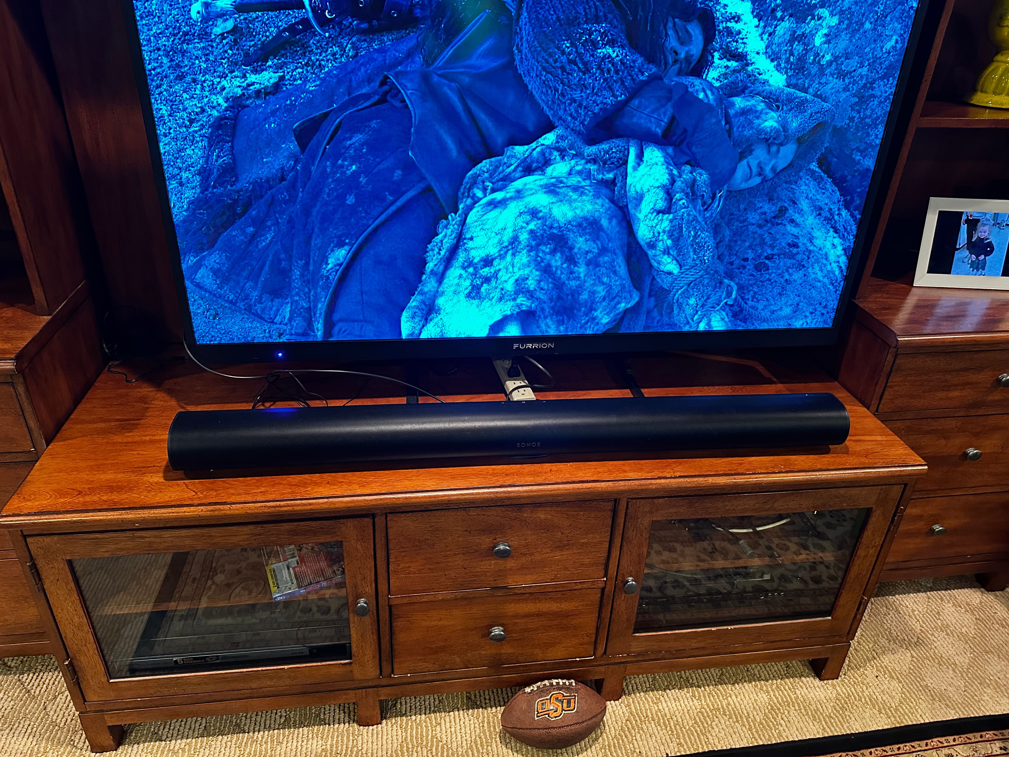 a photo of Sonos Arc soundbar connected to a smart TV on an entertainment center