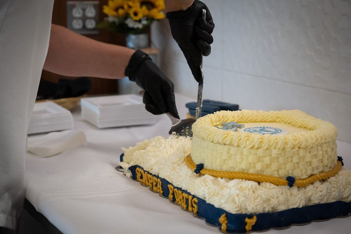 Person in gloves cutting a decorated cake with "Expert Pacts" on the side.
