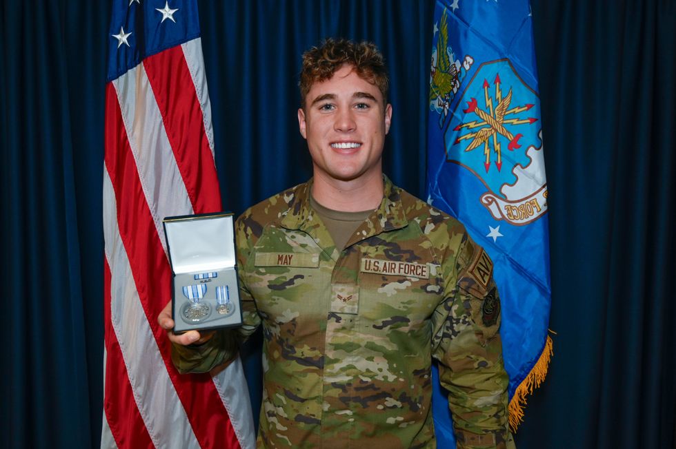 Air Force Airman Troy May holding achievement medal