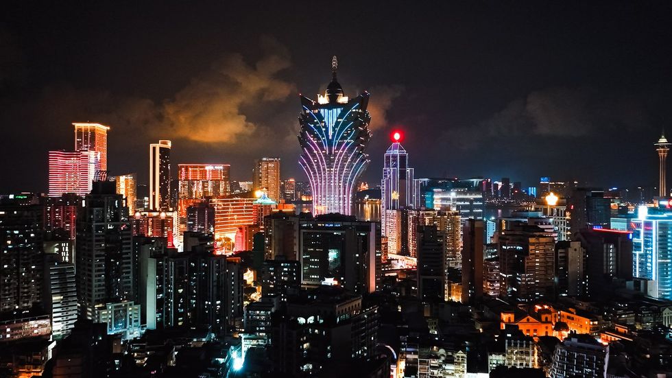Cityscape view of Grand Lisboa Casino skyscraper building at Macau island, financial business or entertainment district. Drone aerial night view.