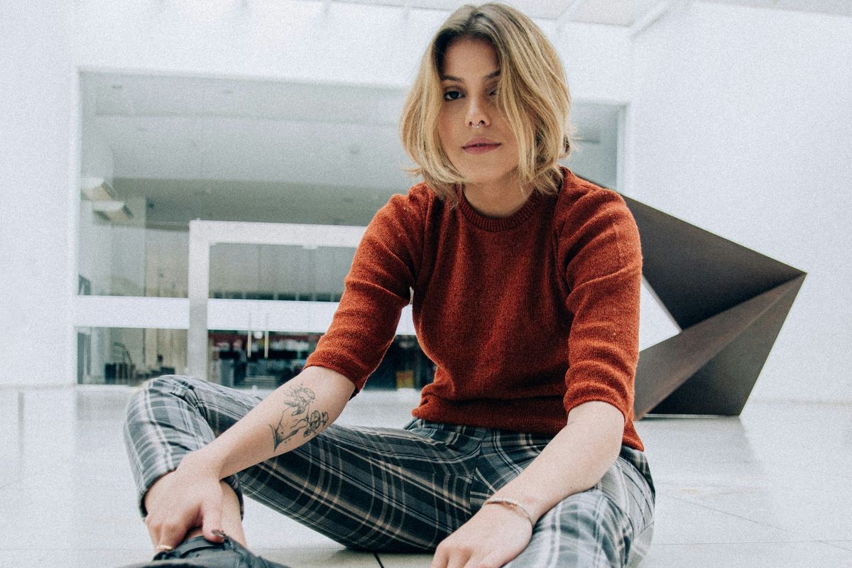 woman sitting on floor tiles inside building