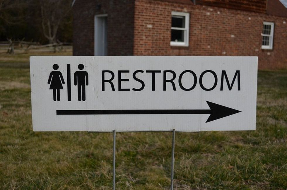 A male and female restroom sign with arrow pointing to the right