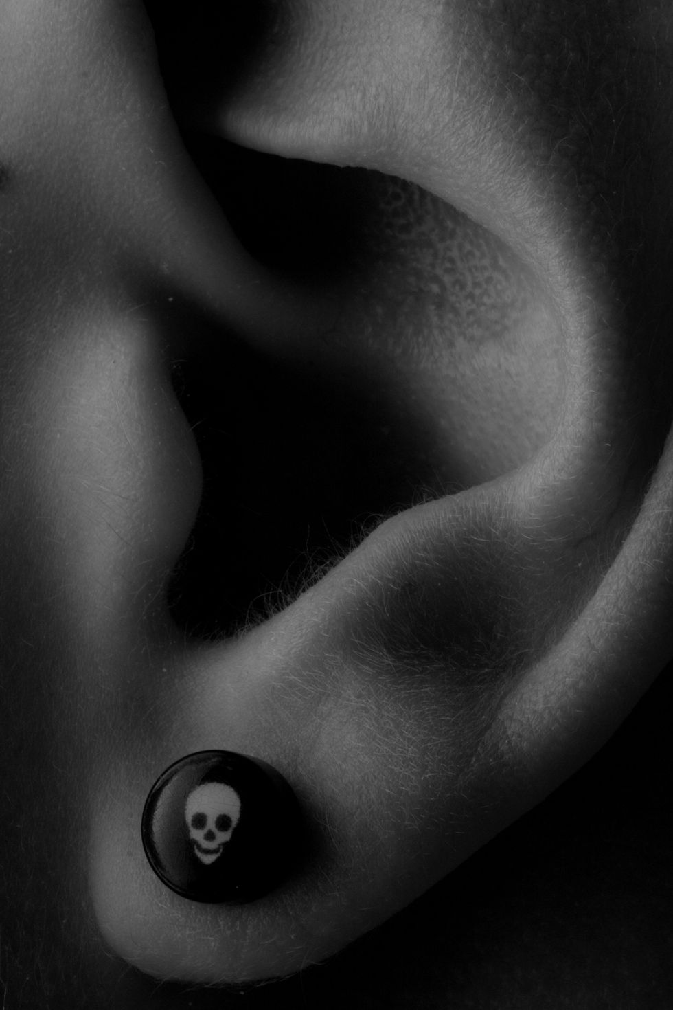 Close-up of an ear with skull earring