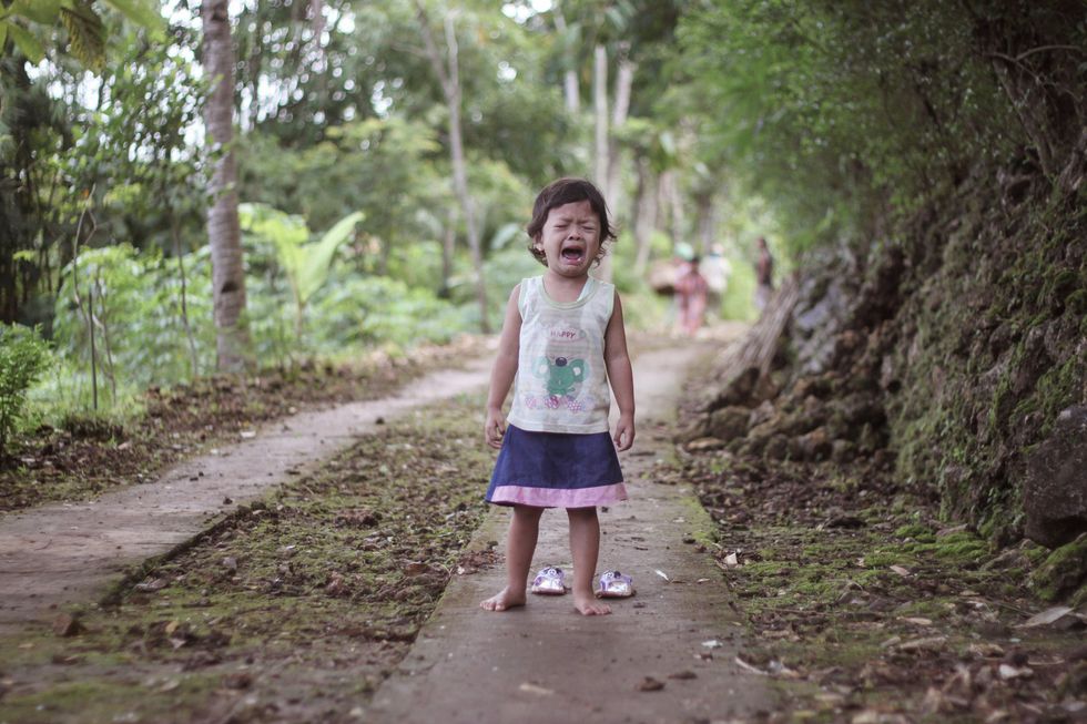girl crying on the sidewalk