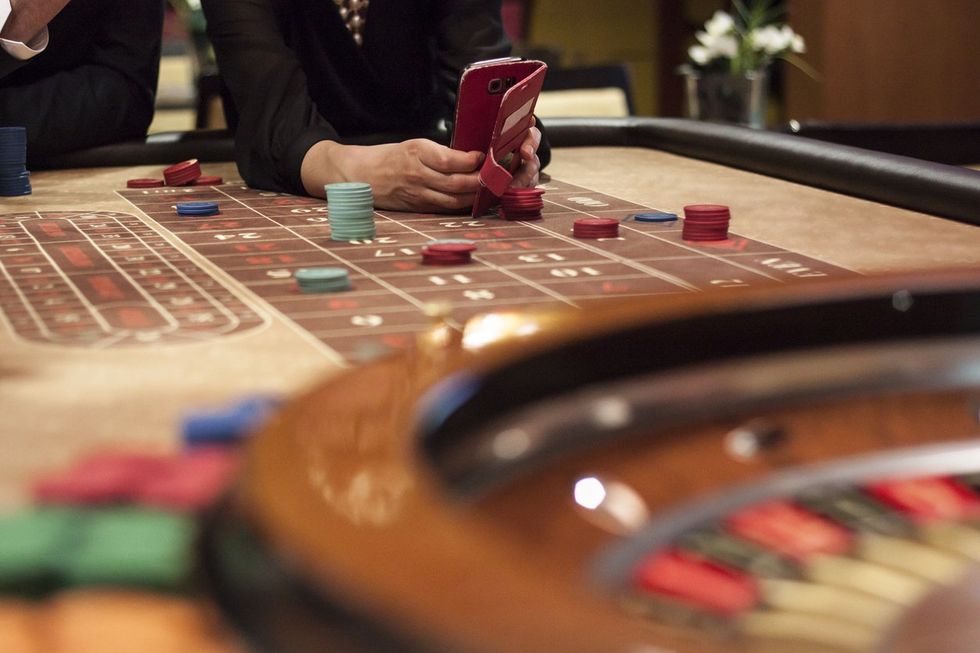 Using Mobile Phone While Playing Roulette in Casino stock photo