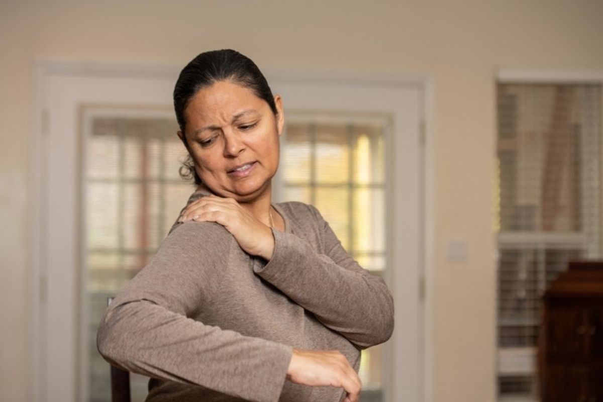 woman grabbing her shoulder